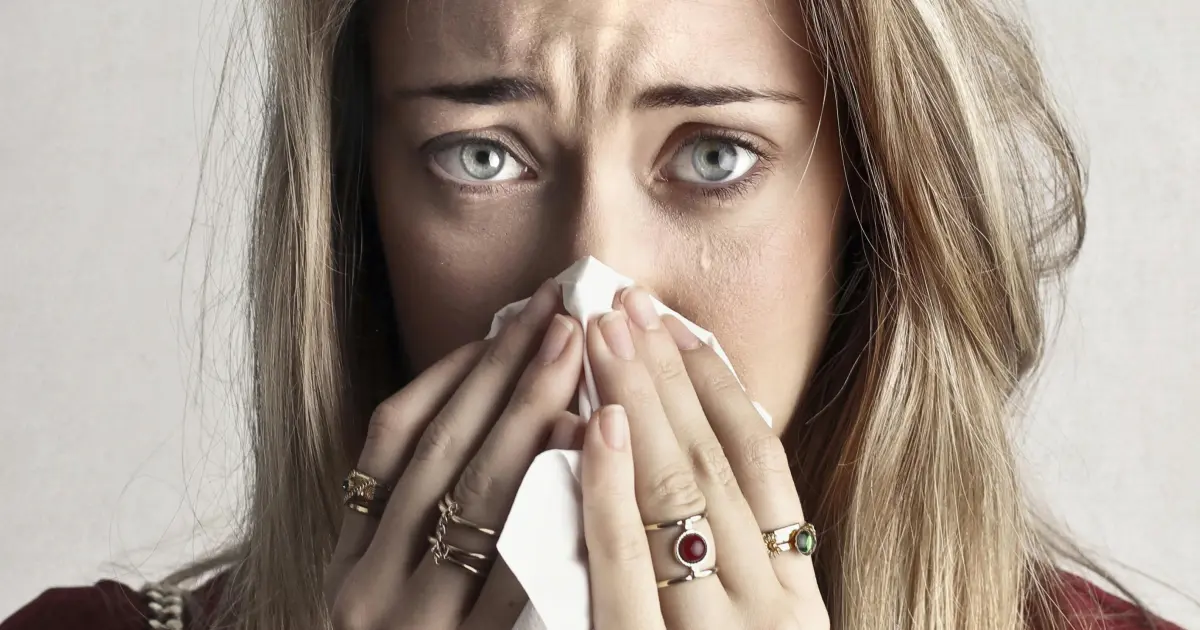 Ragazza allergica che si soffia il naso